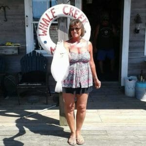Nancy Cunningham holding flounder catch on dock at Whale Creek Marina